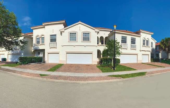 a large white house on the corner of a street at The Falls of Portofino, Naples, FL, 34119