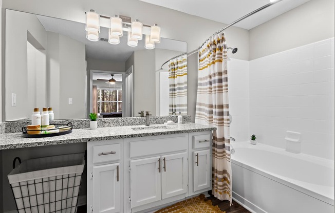 A bathroom with a white tub, sink, and shower curtain.