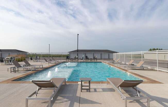 A large outdoor swimming pool surrounded by sun loungers.