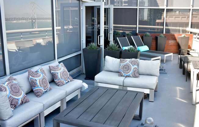 A patio with a couch, table and chairs.