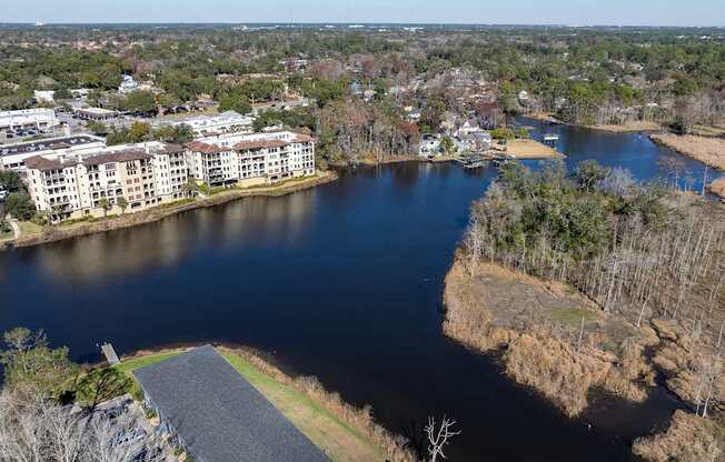 A river flows through a city with apartment buildings on one side and a grassy area on the other at Mandarin Bay Apartments
