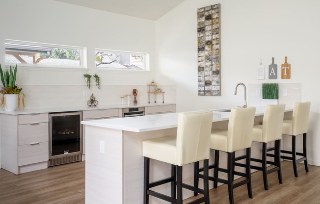 a kitchen with white cabinets and a white island with a white countertop and a row of