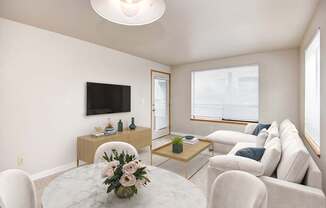 A living room with a white couch, a coffee table, and a flat-screen TV.