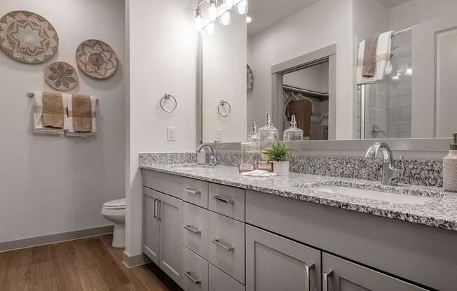 a bathroom with two sinks and a mirror and a toilet