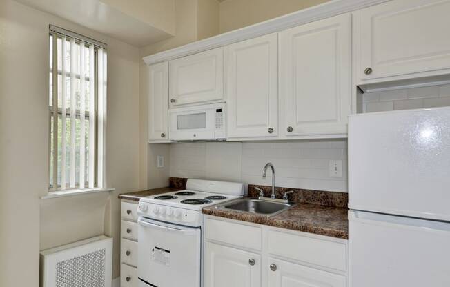 Kitchen With White Cabinetry And Appliances at Majestic, Washington