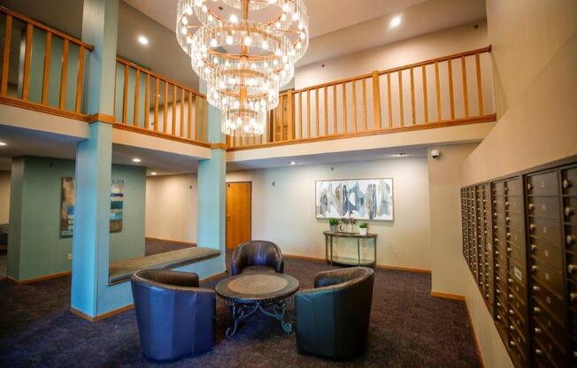 a lounge area with blue chairs and a chandelier