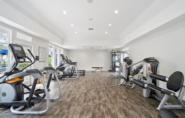 a gym with cardio machines and weights on the floor