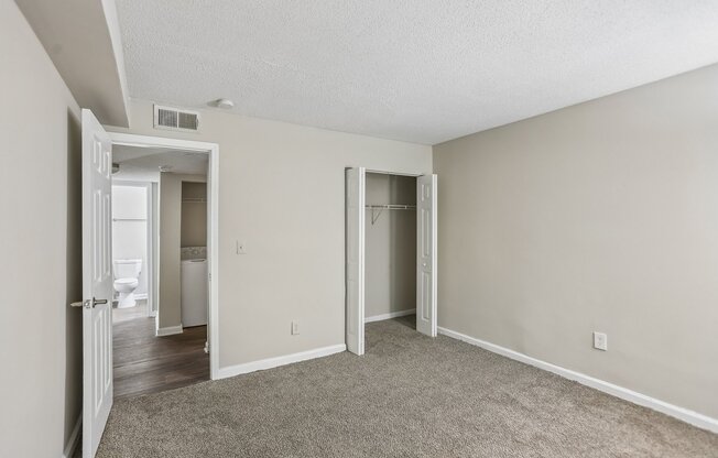 A room with a carpeted floor and a white door.