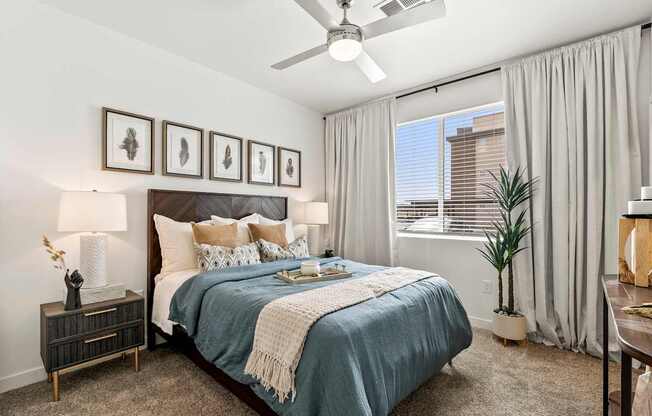 A bedroom with a bed, nightstand, and a ceiling fan.
