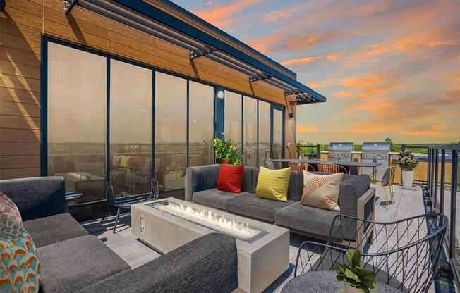 a living area with couches and a table with a fire pit