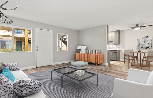 Living room with hardwood floor and view of kitchen and dining area.