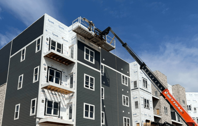 a large apartment building under construction with a crane in the background