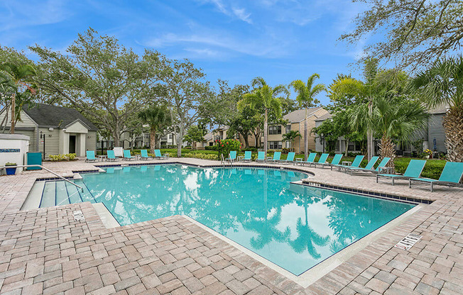 Community Swimming Pool with Pool Furniture at Huntington Place Apartments located in Sarasota, FL.