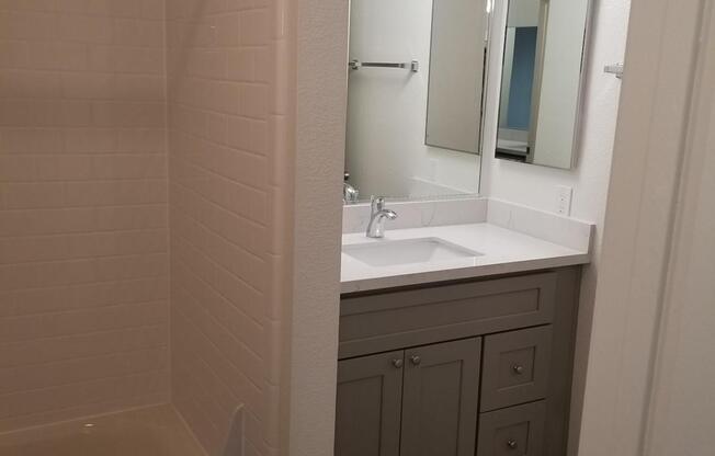 2x1 Bathroom with white countertop and grey cabinets