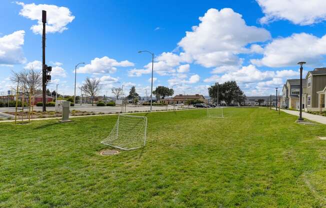 Grassy area with two smaller soccer goals set up.  Sky is bright blue with large white clouds at Morgan Ranch Apartments, Morgan Hill, CA, 95037
