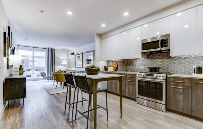 an open kitchen and living room with a table and chairs