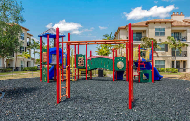 A playground with a red swing set and a blue slide.