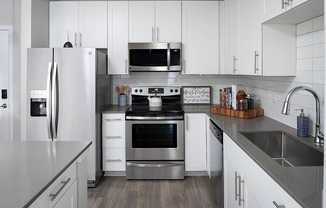 a kitchen with stainless steel appliances and white cabinets