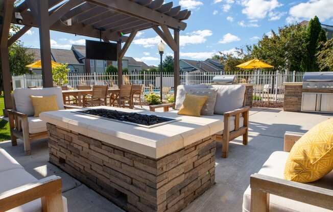an outdoor patio with a firepit and a pergola