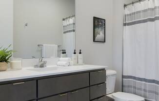 a bathroom with a toilet sink and shower in a 555 waverly unit