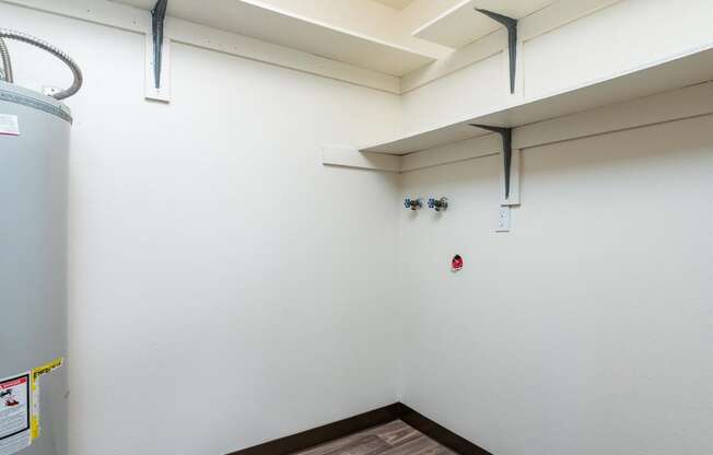 Pinewood Terrace Apartments | Washer and Dryer Hookup close with shelving and water heater.