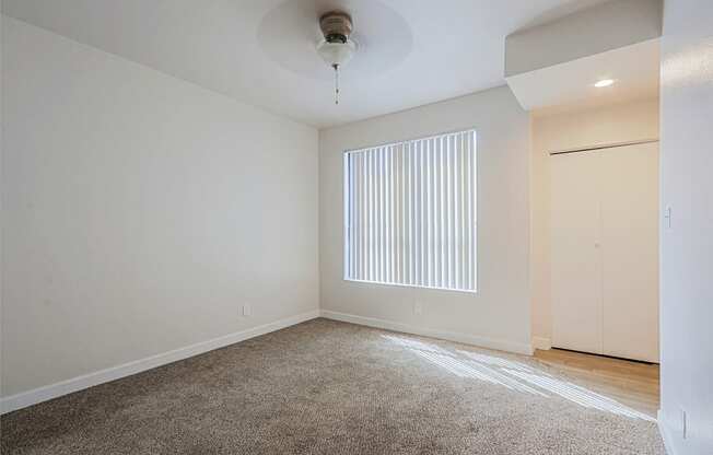 an empty living room with a window and a closet