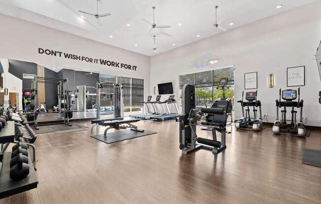 A gym with a variety of equipment including treadmills, weights, and exercise machines.