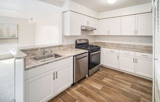 an upgraded kitchen with white cabinets and stainless steel appliances at Black Sand Apartment Homes in Lincoln, NE