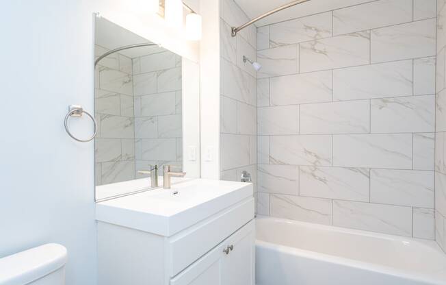 a white bathroom with a sink and a mirror