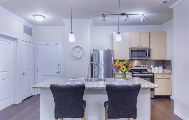 a kitchen with a large island with two chairs in front of it