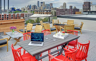 Coze Flats rooftop with downtown skyline view, red high top chairs and outdoor firepit