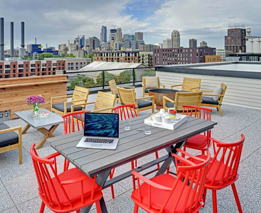 Coze Flats rooftop with downtown skyline view, red high top chairs and outdoor firepit