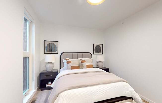 Bedroom with a large bed and two pictures on the wall at One West Drive Apartments, Excelsior, Minnesota