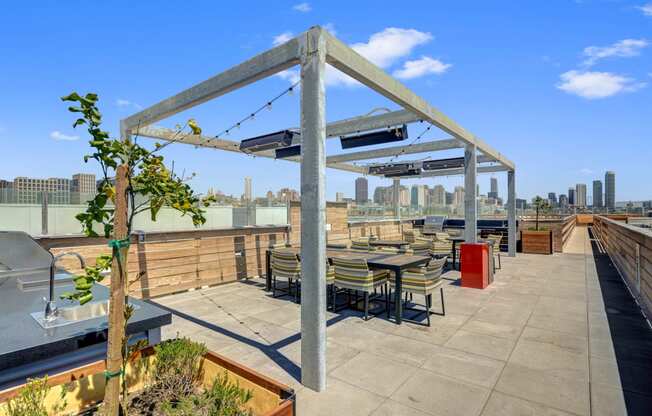 a rooftop patio with tables and chairs and a view of the city at L Seven, California