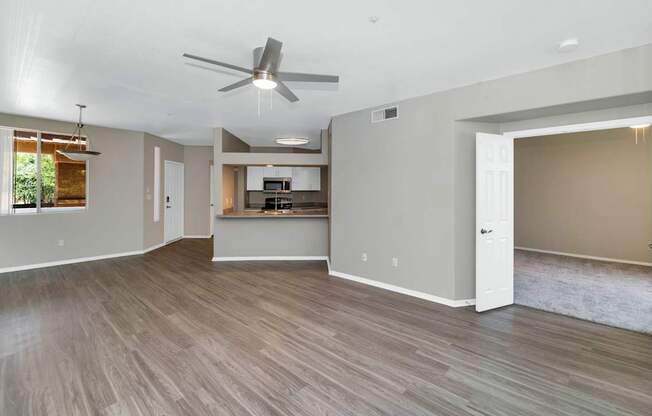 A spacious room with a ceiling fan and lighting fixtures.
