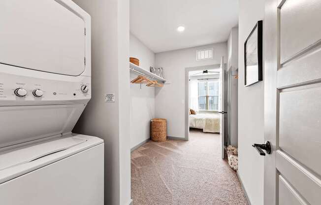 A white washing machine is in a narrow hallway