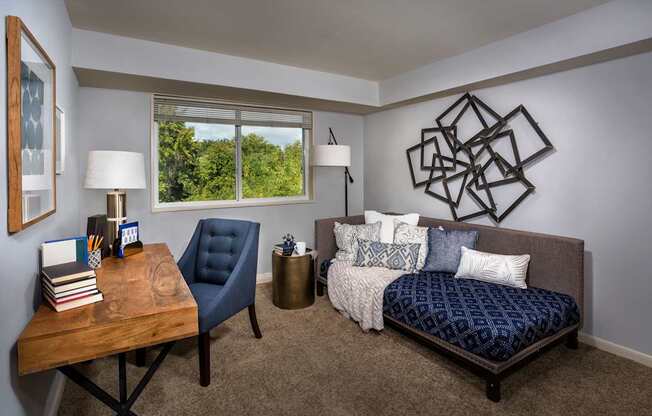 A bedroom with a bed, chair, and table.