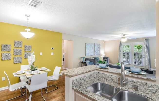 an open kitchen and dining room with a table and chairs at Avalon Apartment Homes in Starkville, Mississippi 39759