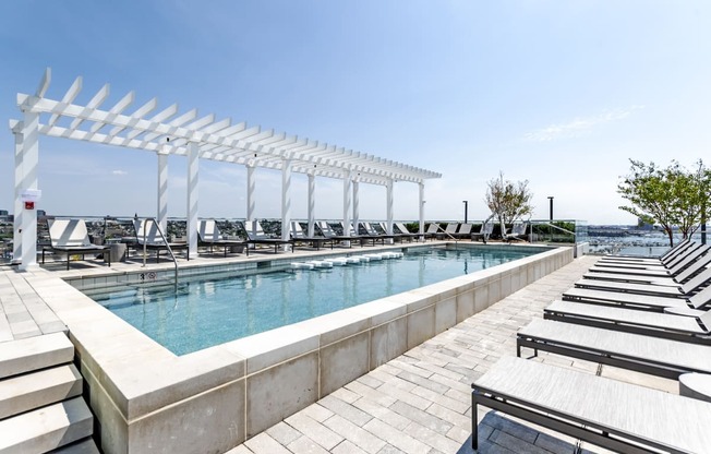 a swimming pool with lounge chairs and a white canopy over it