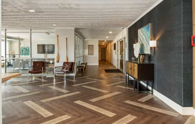 a lobby with chairs and a table and a hallway with wood floors at The Lafayette Apartments, Colonial Place, Norfolk