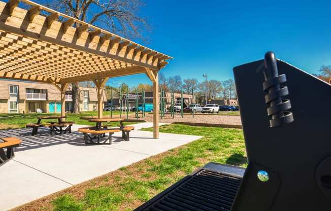 a grill in front of a park with picnic tables  at Bayville Apartments, Virginia Beach, 23455