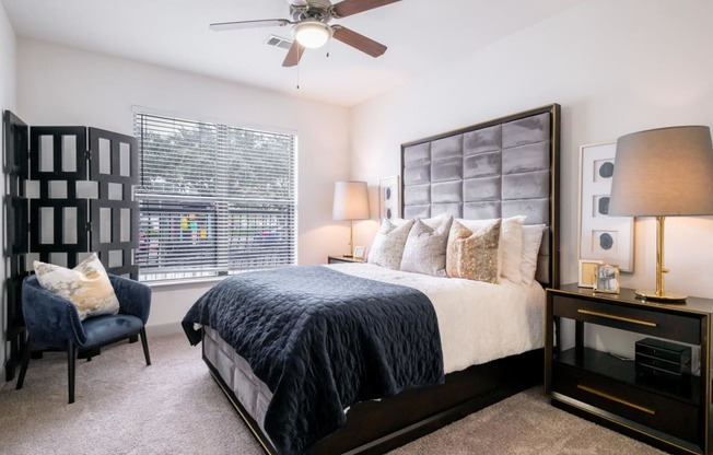 a spacious bedroom with a ceiling fan and expansive windows at The Core apartments in Houston, TX