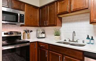 A kitchen with brown cabinets at Poplar Glen Apartments, Columbia, Maryland.