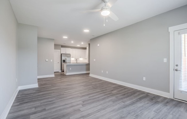 the living room and kitchen in a new home with a ceiling fan