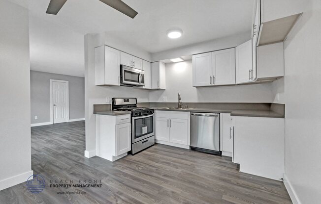 an open kitchen with white cabinets and stainless steel appliances