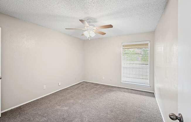 a bedroom with a ceiling fan and a window