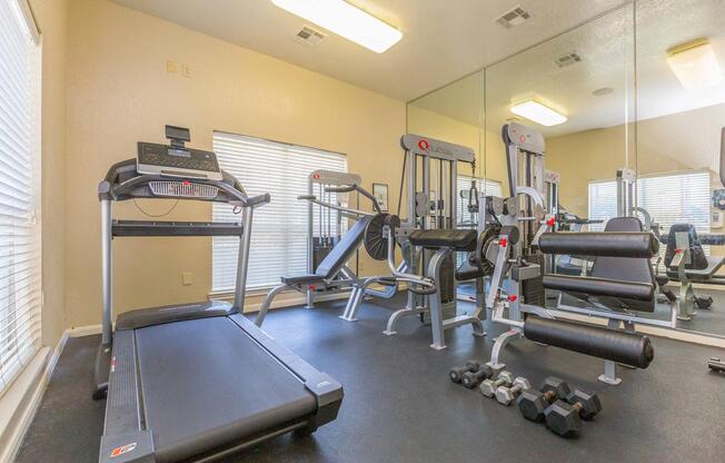 Fitness center with quality equipment in front of mirror in The Avenue apartments for rent