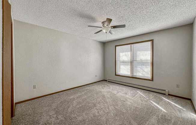 an empty living room with a ceiling fan and a window at Creekstone Falls, South Dakota, 57106