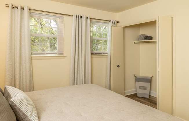 a bedroom with a bed and two windows