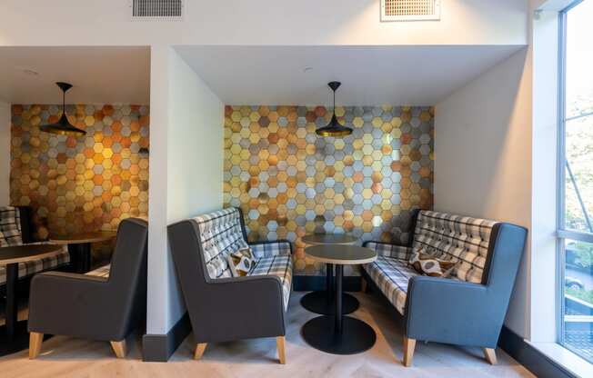 a living room with couches and chairs and a wall with geometric tiles